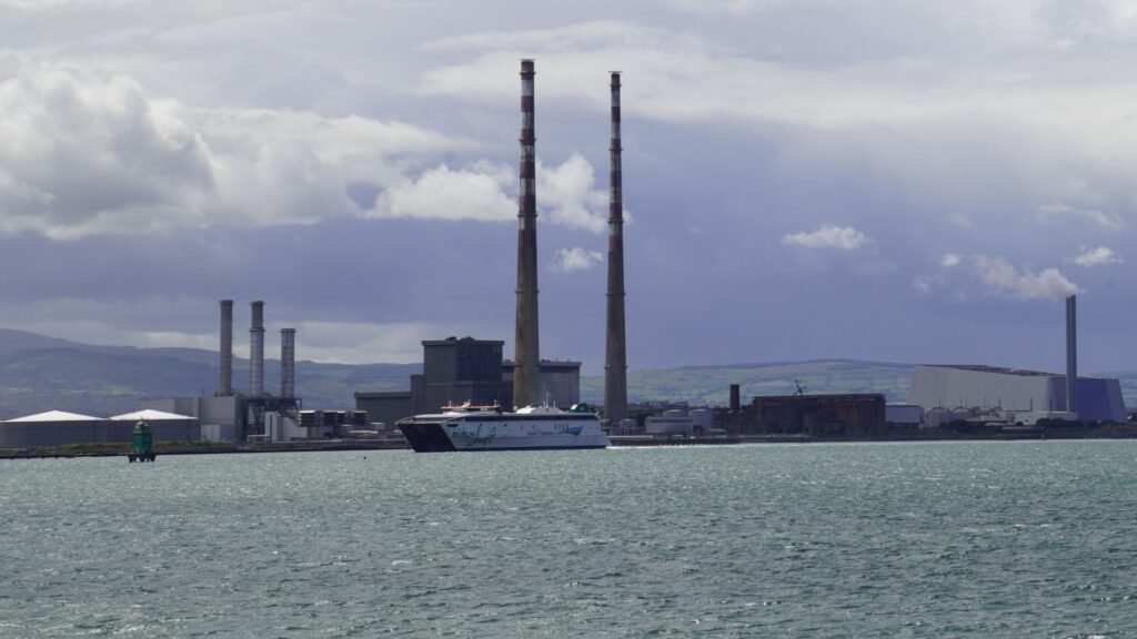 Ferry passing two tall chimneys at a coastal power station